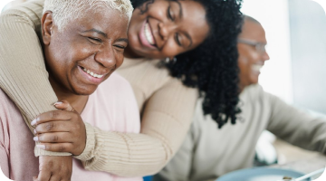 A woman holding another elderly woman